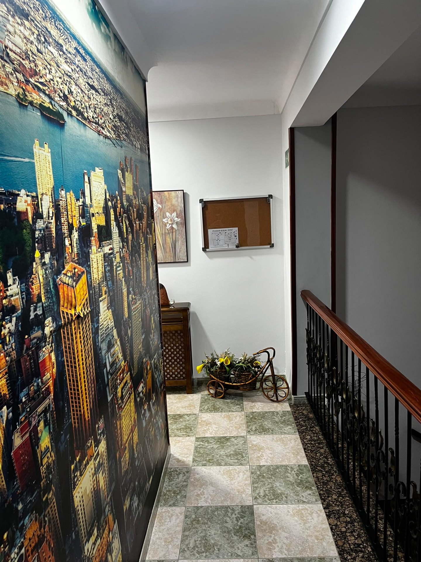 Pasillo decorado con mural y rincón con flores