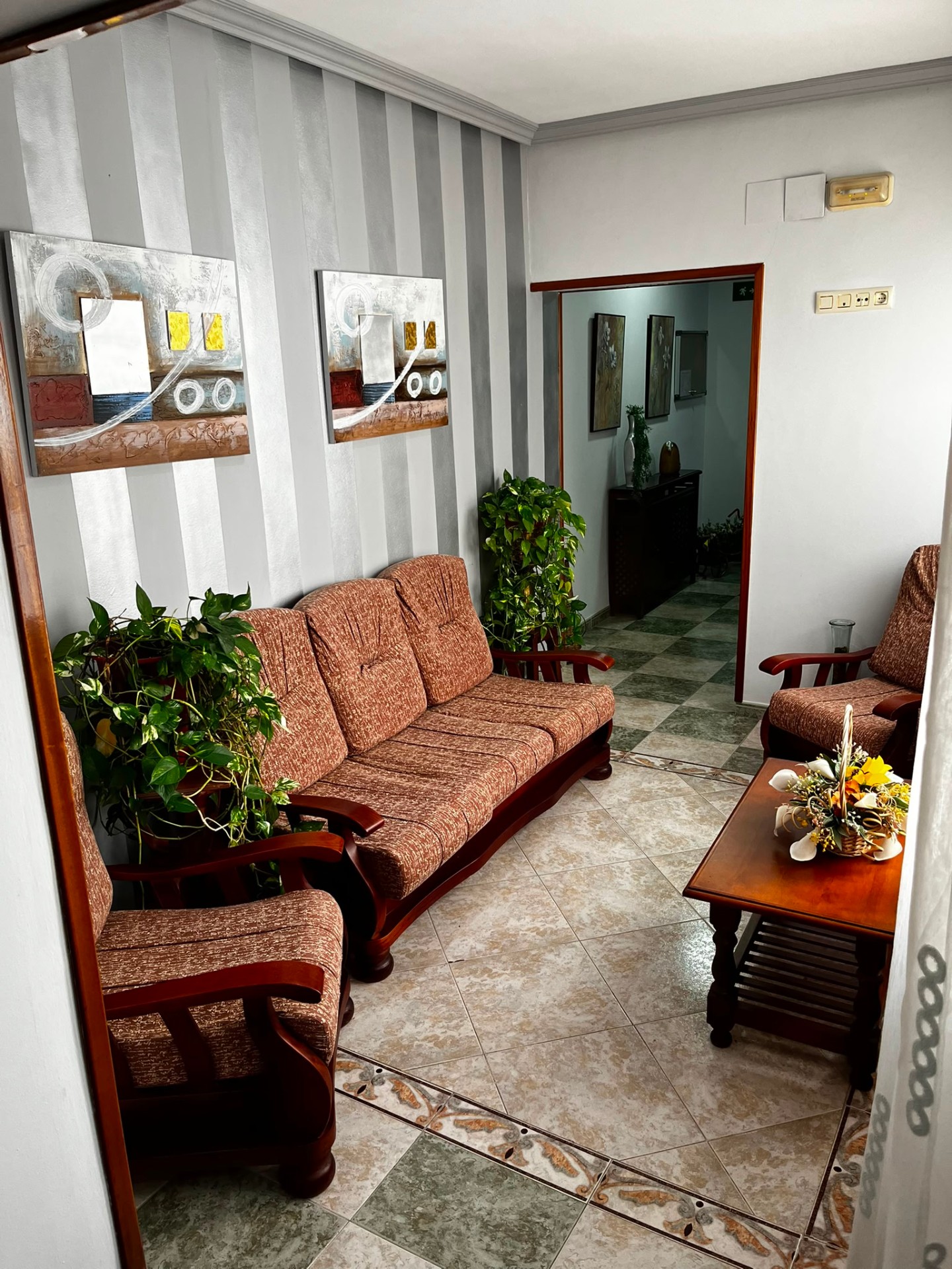 Zona de estar con sofás y cuadros decorativos